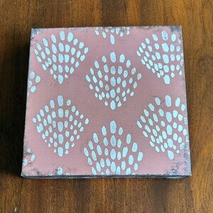 8.5” by 8.5” wooden Coral/Salmon and white patterned wall art.
